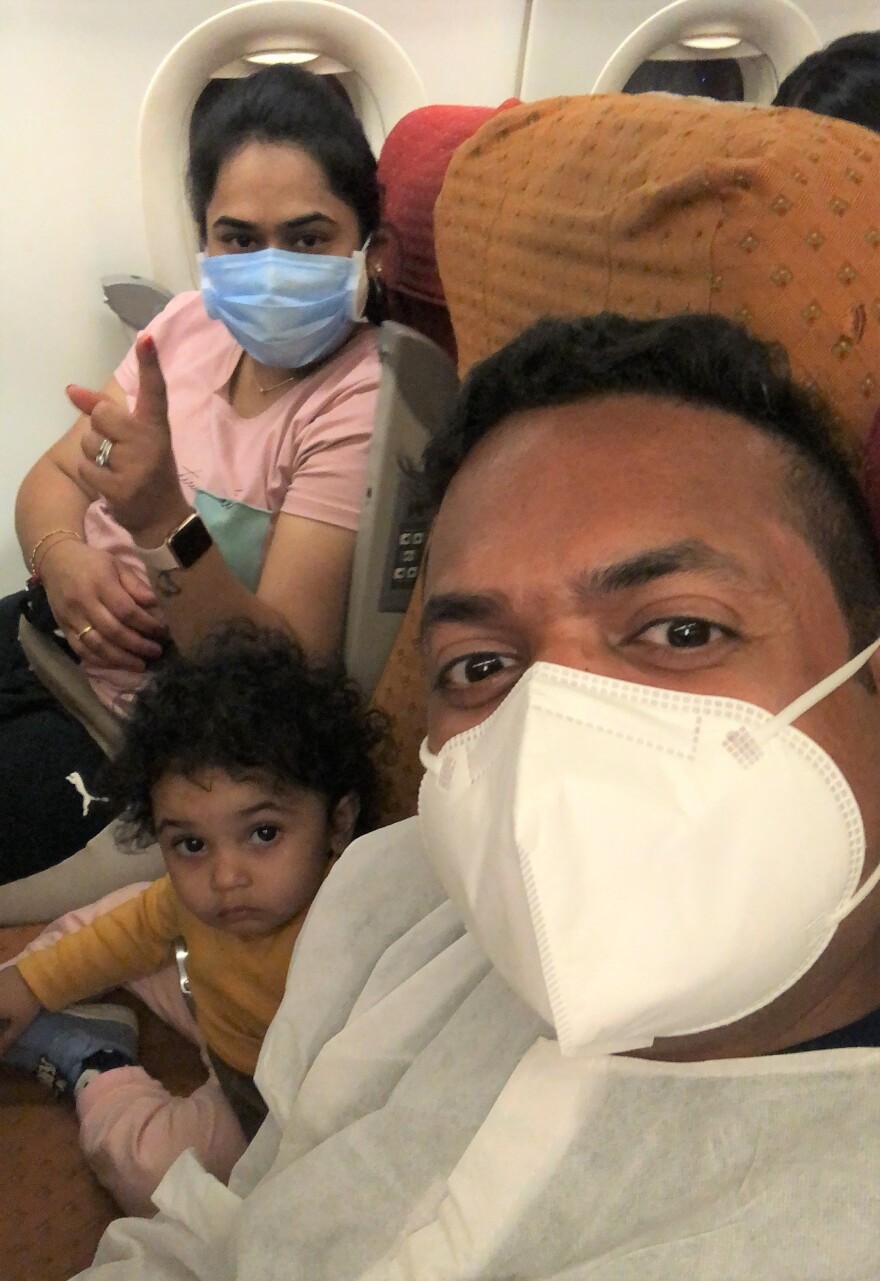 Dhaval Babu with his wife, Maitre, and daughter on their flight from India to the U.S.