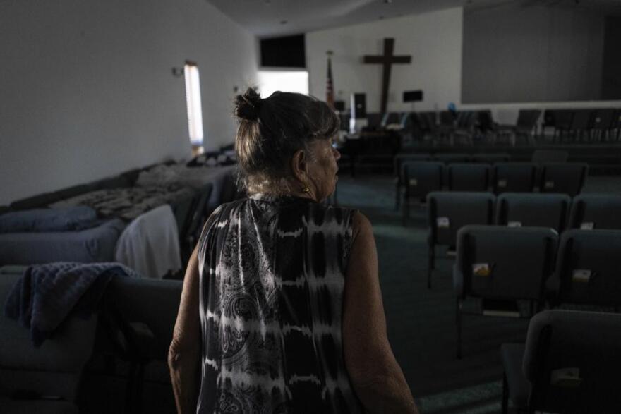 Barbara Wasko walks through the sanctuary of the Southwest Baptist Church in Fort Myers, Fla., Sunday, Oct. 2, 2022. She took refuge inside the church when Hurricane Ian swept through Southwest Florida.