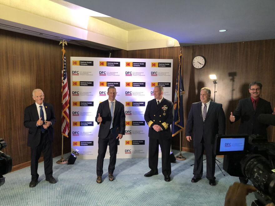 Various federal and Kodak officials gather for a photo-op after the signing of the deal that will provide the company with a $765 million loan.