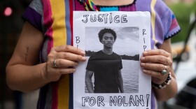 FILE - A person holds a picture of Nolan Xavier Wells during a news conference at National Action Network headquarters, Friday, July 10, 2026, in New York. (AP Photo/Yuki Iwamura, File)