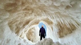 Juniper Schaberg stands tall at the entrance of an ice cave at Sleeping Bear Point over the weekend. (Photo courtesy of James Schaberg)