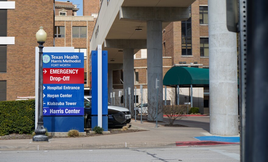 The outside of Texas Health Harris Methodist. A sign shows directions to the emergency drop-off and hospital entrance.