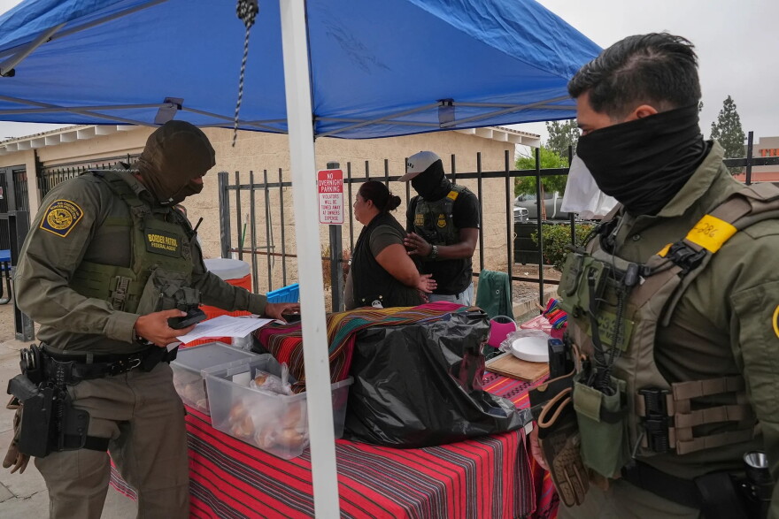 A woman is detained by U.S. Border Patrol agents outside a Home Depot in Los Angeles on Aug. 15, 2025.