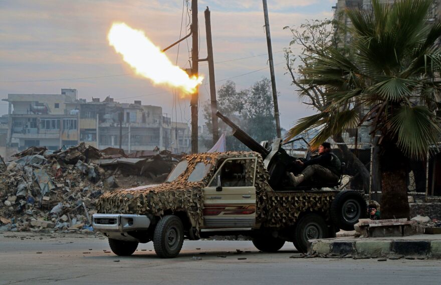 Fighters of the Free Syrian Army fire an anti-aircraft weapon in Aleppo's rebel-held area of Mashhad on Monday, as they battle Syrian government forces.