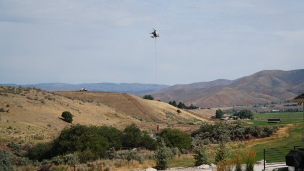A helicopter pulls water from a pond near Bret Hadley's home to fight the Rocky Canyon Fire, Aug. 12, 2026.