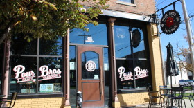 The Pour Brothers Taproom has an attractive facade with signage along the widows and an attractive sign hanging from the front of the building.