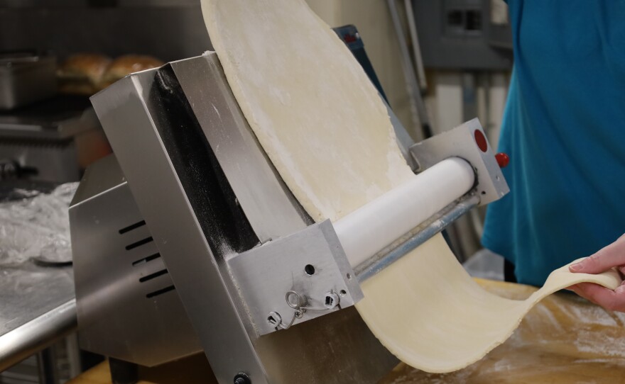 Wallace feeds pie dough through a dough sheeter machine. Photo by Allison Diaz.