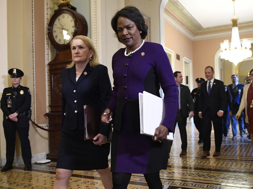 Impeachment managers Rep. Val Demings, D-Fla., center, and Rep. Sylvia Garcia, D-Texas, left, walk to the Senate trial of President Trump in February.