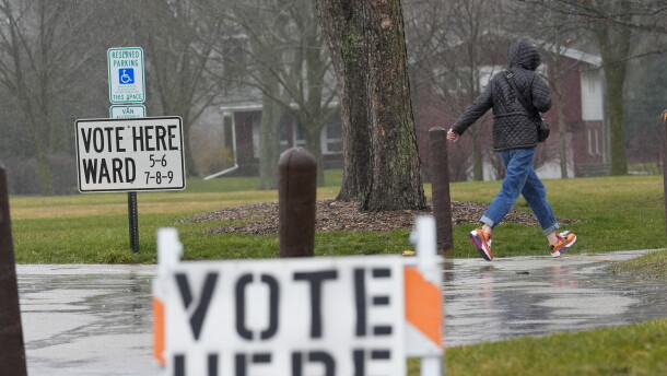 A voter braves a cold rain running to cast a ballot during the Spring election Tuesday, April 2, 2024, in Fox Point, Wis. (AP Photo/Morry Gash)
