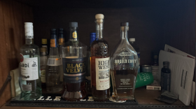 A few bottles of liquor in a cabinet.