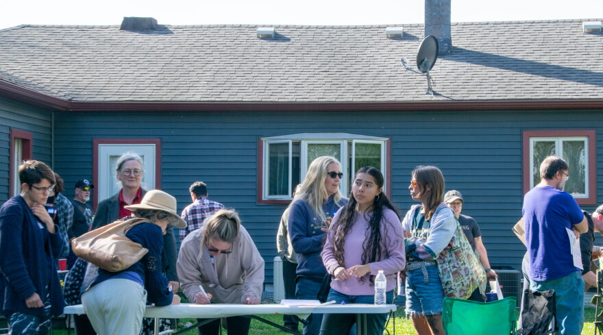 Several community members gathered around a folding table in a backyard to leave comments and concerns.