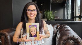 Rebecca Reed holds a photo of her daughter, Isla Rose Melucci. Isla died in her sleep from Sudden Unexplained Death in Childhood in March.