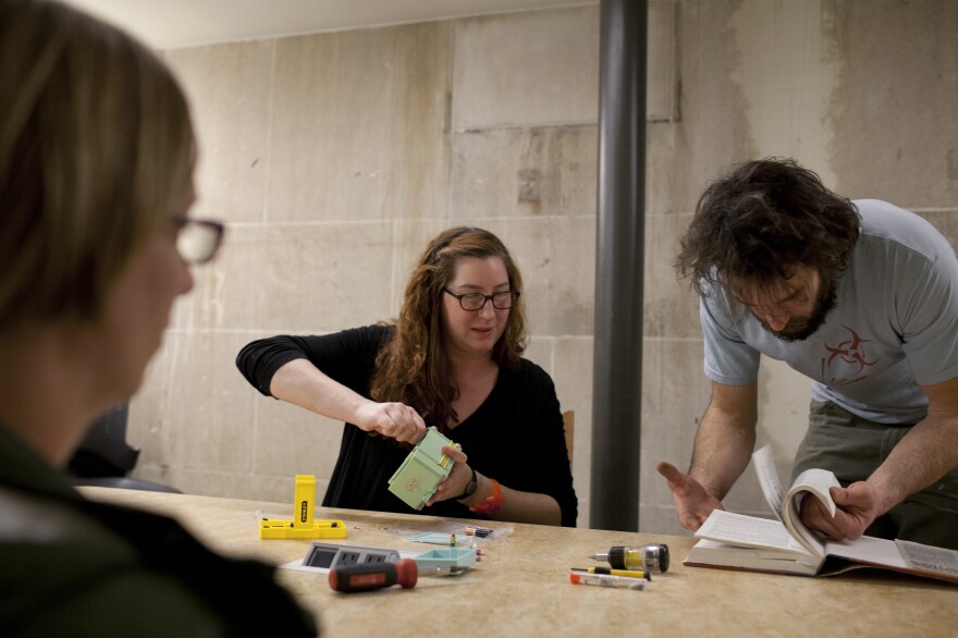 Matt McEntee (right) helps Esti Brennan (middle) fix her Polly Pocket clock while Susanne Unger (left) observes the process.