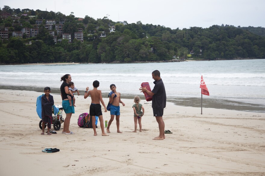 In this Wednesday, July 7, 2021, photo, tourist Liron Or, second from left, from Israel, and her family enjoy their vacation on Patong Beach Phuket, southern Thailand. (AP Photo/Tiwa Suvarnabhanu)