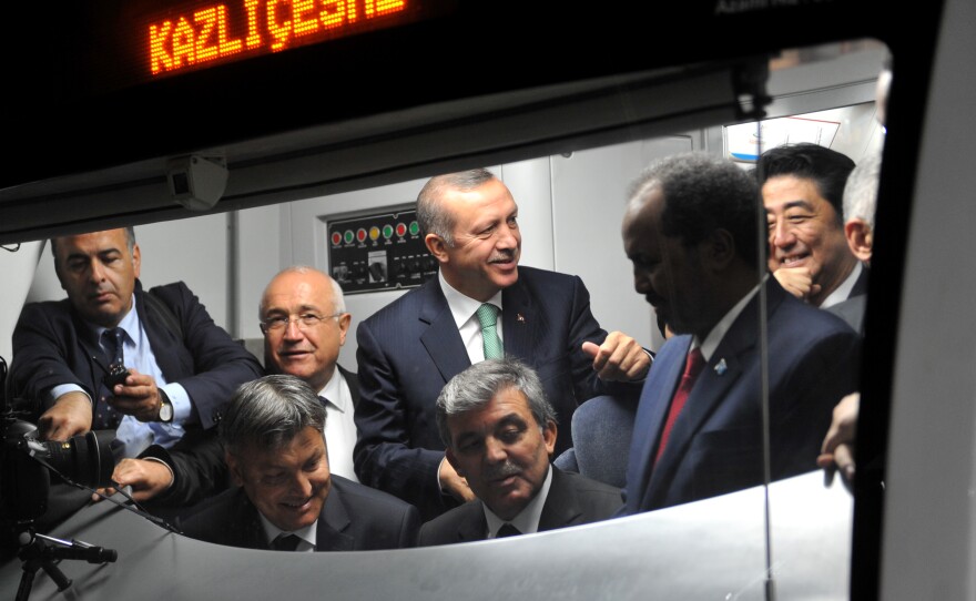 Japanese Prime Minster Shinzo Abe (right), Somalian President Hasan Sheikh Mahmud, Turkish President Abdullah Gul and Turkish Prime Minister Recep Tayyip Erdogan listen to an announcement in a train car at the Uskudar Marmaray station ahead of its inauguration ceremony in Istanbul, on Tuesday.