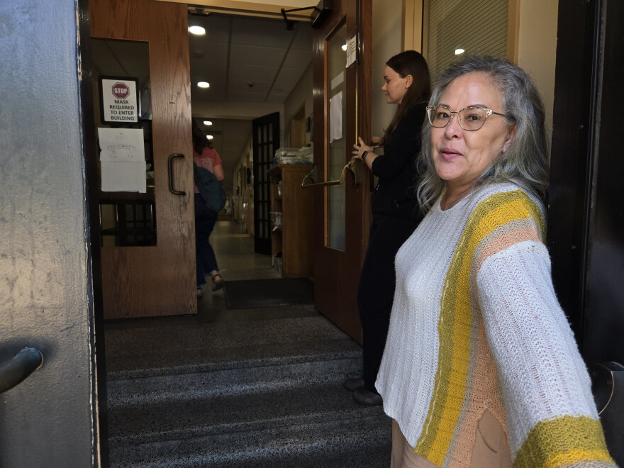 Executive director of the Cathedral Center, Donna Rongholt-Migan, opens the door for a delivery of Veggie Chop Shop meals.