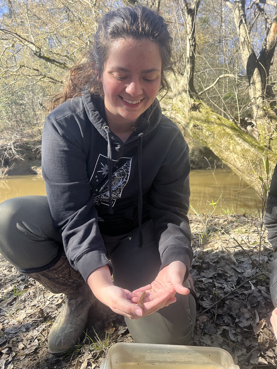 Water Quality Specialist Taylor Register Seijo holds a Neuse River Waterdog, listed as threatened on the Endangered Species list.