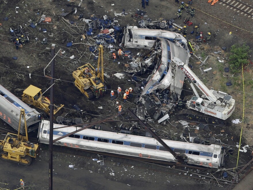 Emergency personnel work at the scene of a deadly train wreck, on Wednesday. The FBI is now looking into the possibility that the locomotive was struck by some sort of projectile.