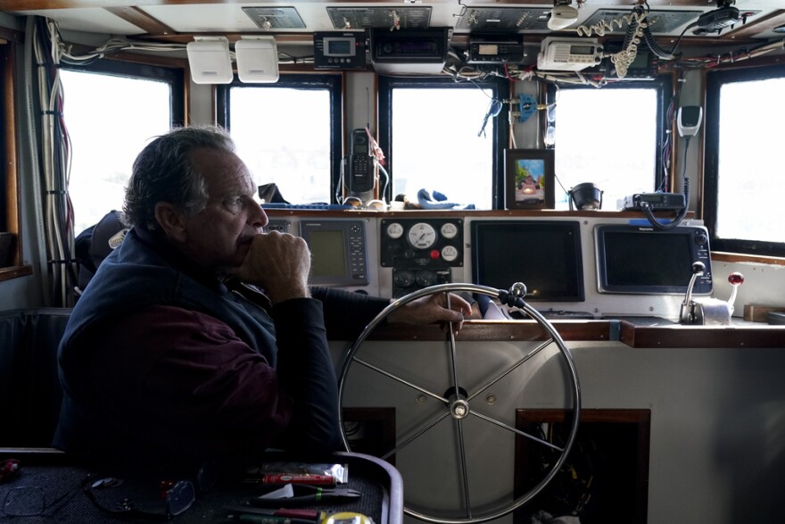 Bob Maharry sits inside his fishing boat docked at Pier 45 in San Francisco, Monday, March 20, 2023. This would usually be a busy time of year for Maharry and his crew as salmon fishing season approaches. On April 7, the Pacific Fishery Management Council, the regulatory group that advises federal officials, will take action on what to do about the 2023 season for both commercial and recreational salmon fishing.