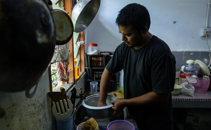 Mohd, 32, prepares a dish his mother taught him: a mix of rice, lentils, curry, chopped long beans and chili powder. "Let my wife rest today. I will cook and show you!" he says.