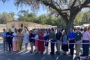 Alachua County Commissioner Ken Cornell (center) cuts the ribbon on a new permanent housing facility for people experiencing homelessness. He is accompanied by a number of county and state officials. (Kristin Chermont Spina/WUFT News)