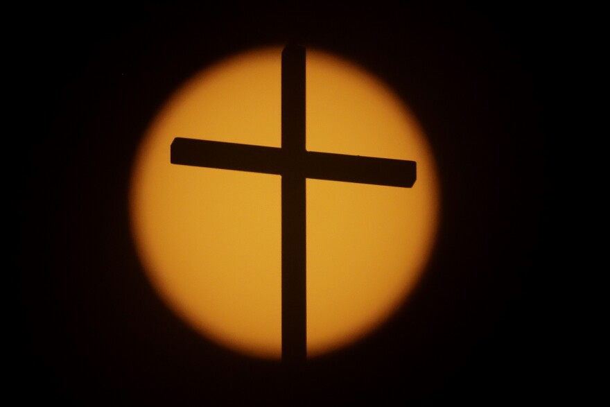 The cross on top of the First Baptist Church is silhouetted in front of the sun on Sunday, Aug. 20, 2017, in Simpsonville, S.C. South Carolina is gearing up for a total solar eclipse, which will cross the state diagonally during a phenomenon that will be seen across the country. (AP Photo/Julio Cortez)