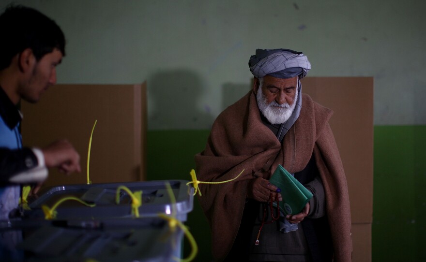 A man prepares to cast his ballot after filling out both the provincial and presidential voting forms in Kabul.