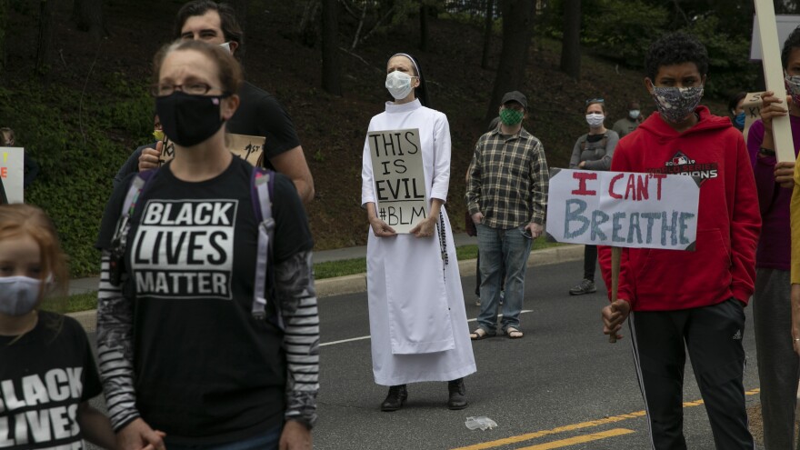 In Washington, D.C., on Tuesday, Sister Quincy Howard protests the arrival of President Trump to the Saint John Paul II National Shrine in Washington.