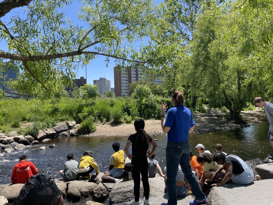 The Director of Education speaks about the Rippowam River restoration in Mill River Park with a group of fifth-grade students during an Environmental Engineers field trip May 31st 2023.