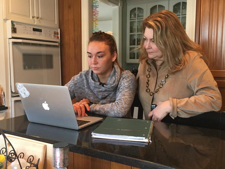 Abbey Lopez, left, with her mom Jennifer in their kitchen where Abby's says she did a lot of her work for ECOT. (Ashton Marra/ideastream)