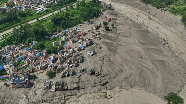 Damaged houses stand precariously near the swollen, debris-choked banks of the Trishuli River after flash floods in Nepal's Nuwakot district on Wednesday, Aug. 26, 2026. (Niranjan Shrestha/AP)