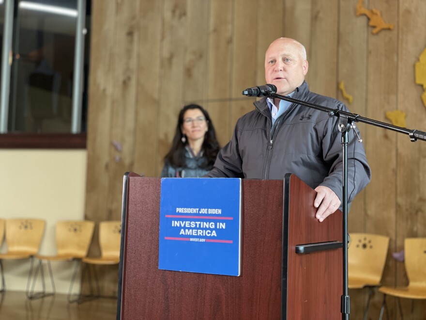 a man stands at a podium, talking into a microphone