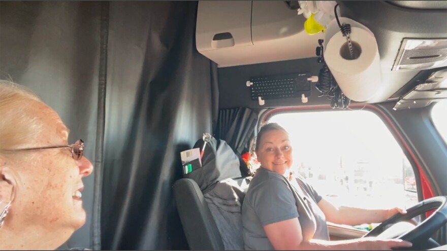 Laura and Terry inside semi-truck with Laura at wheel