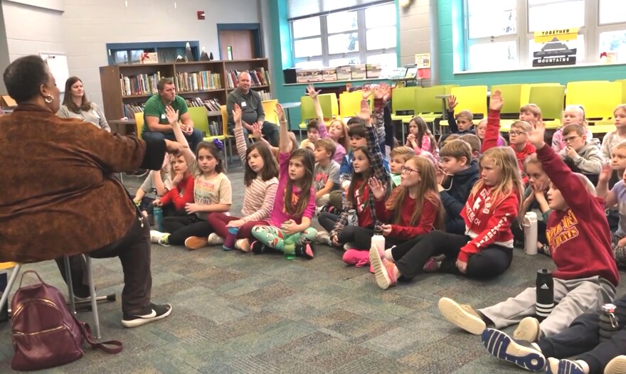 Aretha Sebree Graves teaches local elementary school students about Kwanzaa, topics include why Swahili is used and when the holiday happens each year.