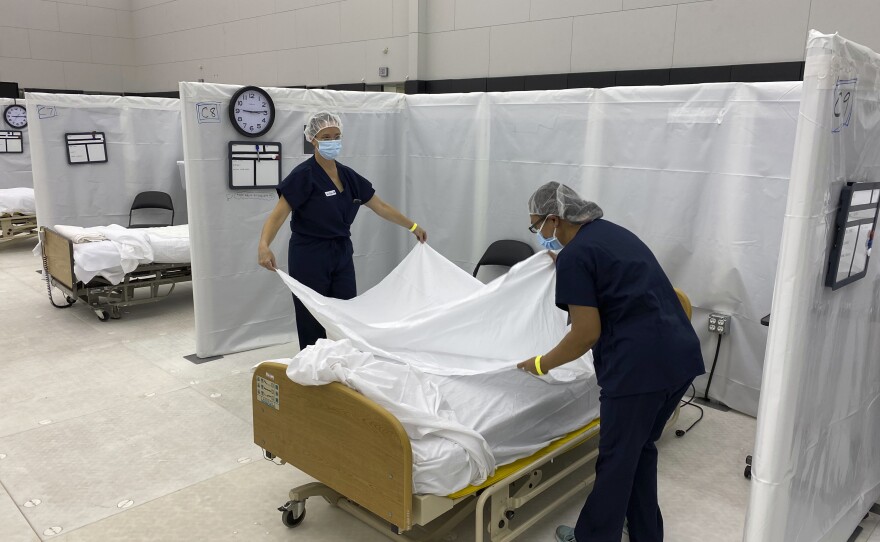 Hospital beds are set up in the practice facility at Sleep Train Arena in Sacramento, Calif. The facility is ready to receive patients as needed as new coronavirus infections and deaths rise in the state.