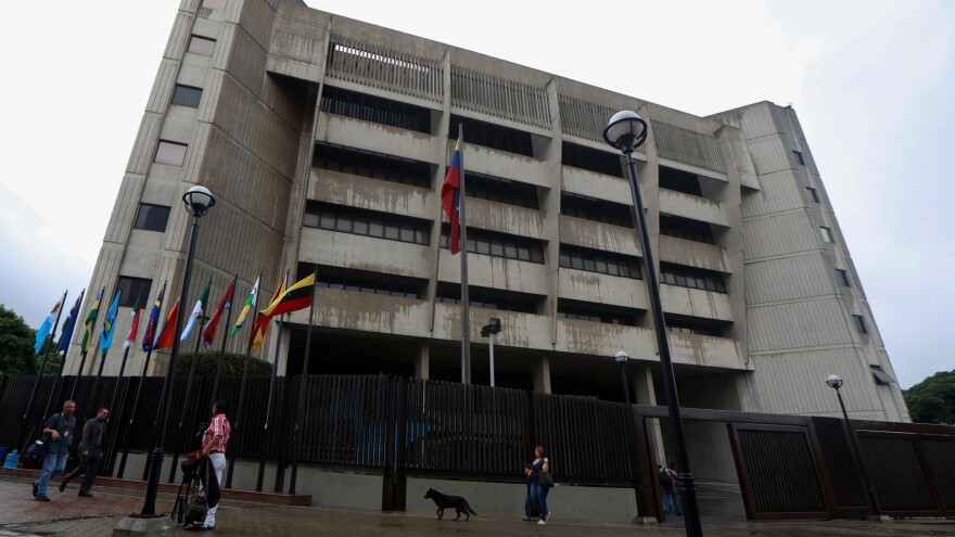 People walk in front of Venezuela's Supreme Court of Justice, in Caracas. Venezuelan Justice Christian Zerpa left the country for the U.S., denouncing the re-election of President Nicolás Maduro.