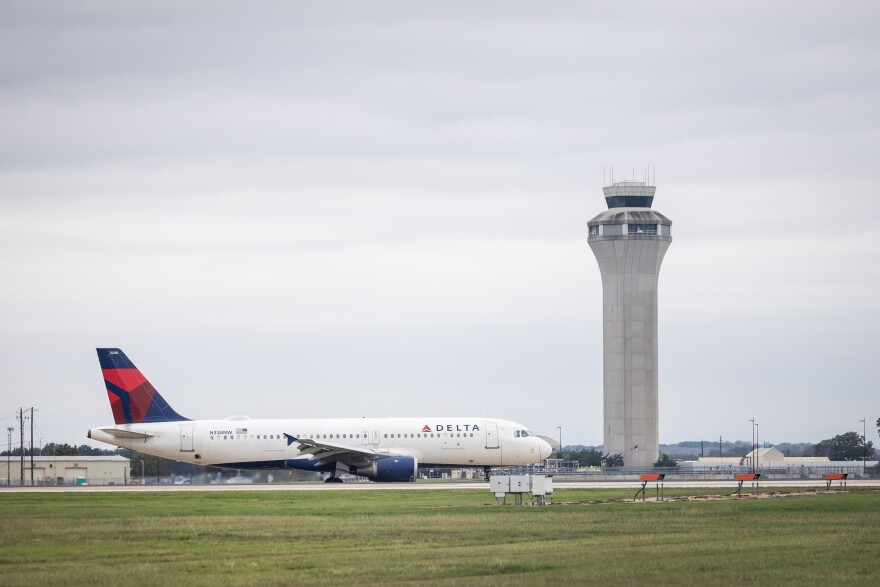 A Delta Airlines plane taxis past the air traffic control tower at Austin-Bergstrom International Airport on Nov. 13, 2023.