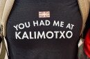 A close-up of someone’s black t-shirt, with a small red, green and white Basque flag and the words “You had me a kalimotxo” on it.  