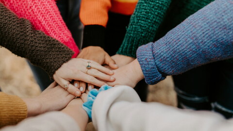 A group of hands stacked on top of each other.