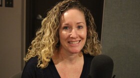 a blonde woman smiles near a microphone