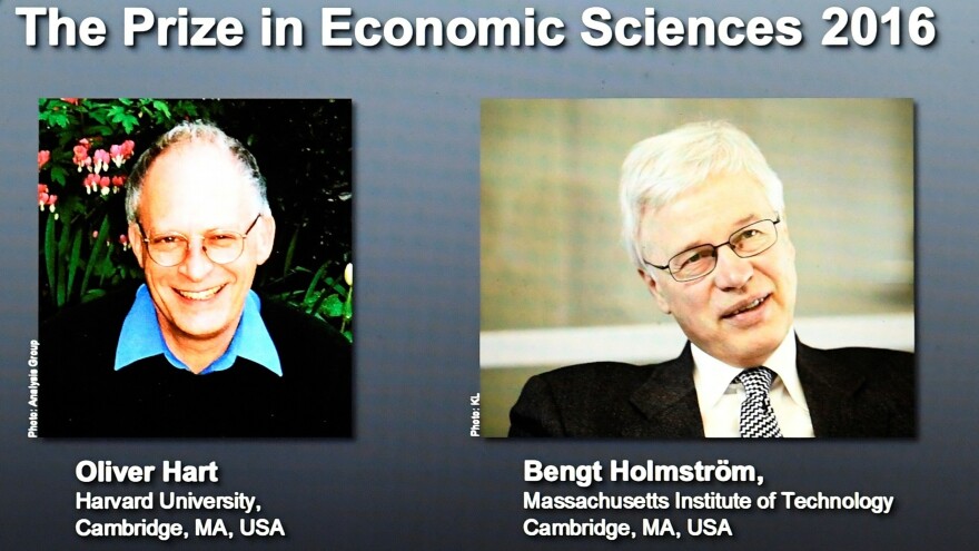 Winners of the Nobel Prize in Economic Sciences, economists Oliver Hart (left) and Bengt Holmström, are displayed on a screen at the Royal Swedish Academy of Sciences in Stockholm on Monday. They won the prize for their work on contract theory.