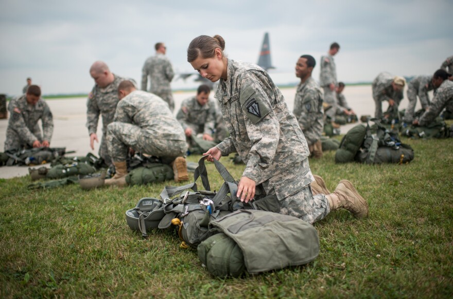 Indiana Army National Guard Pvt. Trea Colon inspects her equipment during a field training exercise at Camp Atterbury and Muscatatuck.