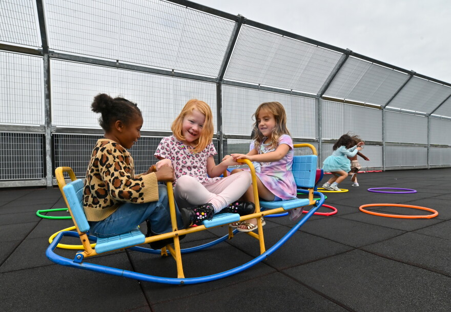 Trinity Paden, Brooklynn Weiss and Kyla Maccarone play on the see-saw of the St. Clair rooftop playground.