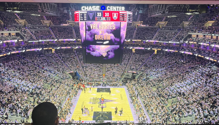A packed Chase stadium in all violet surrounding the basketball court with the Valkyries vs the Dream on the jumbotron.