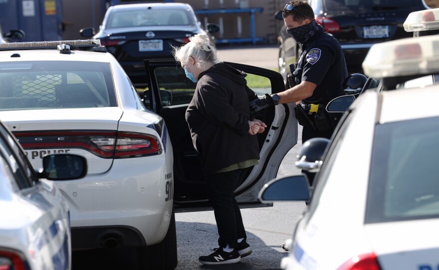 Police detain activist Mary Adams outside the Locust Club headquarters Thursday.