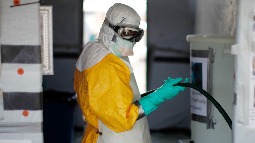 A female sanitation worker wears standard gear for a Doctors Without Borders Ebola center. The outfit includes rubber boots, goggles, a face mask, a hood, three layers of gloves, a Tyvek suit and thick rubber apron. No exposed skin is allowed. She was photographed in Monrovia, Liberia.