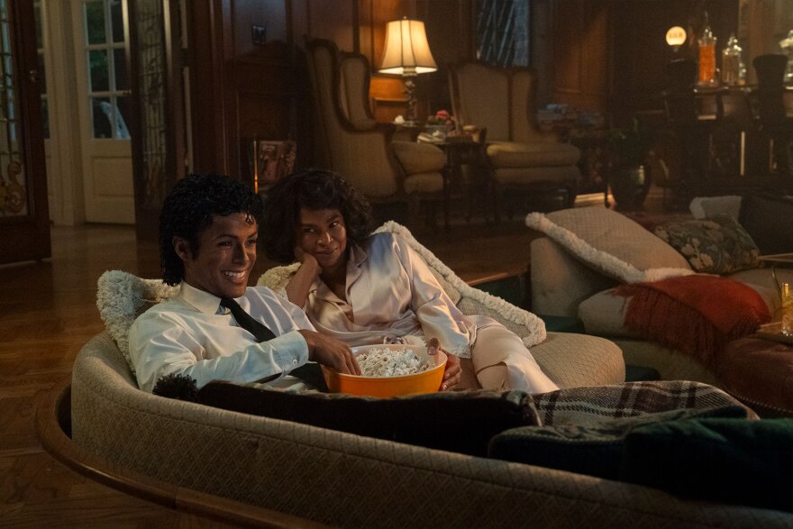 Michael Jackson and his mother Katherine eat popcorn and watch a movie on the couch.