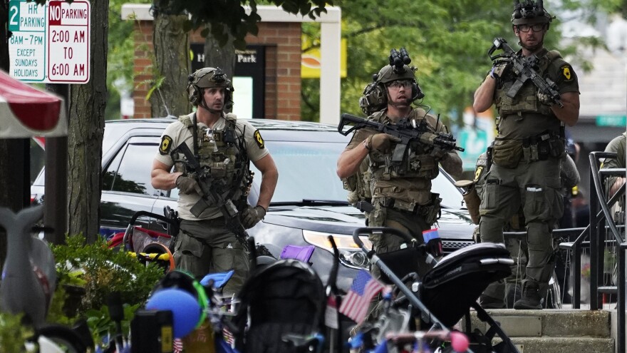 Law enforcement personnel secure the scene after a mass shooting Monday at a Fourth of July parade in downtown Highland Park, a Chicago suburb.