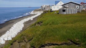 Sand-filled Super Sacks are piled along the eroding coastal bluff in Utqiagvik. New federal funding will help address climate change in rural Alaska.