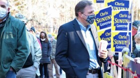 Gov. Chris Sununu greets voters at a polling place early on Election Day, Nov. 3, 2020.